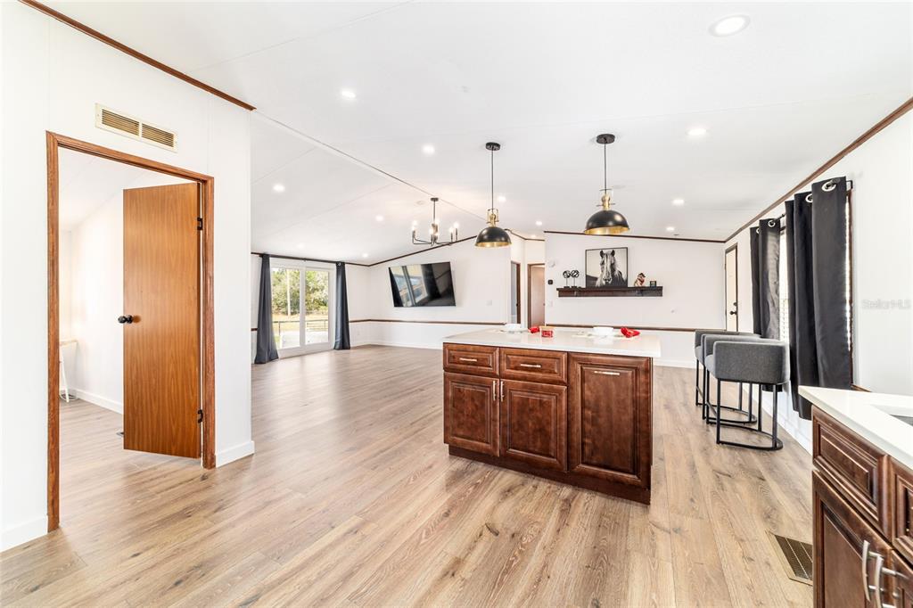 5150 Southeast 117th Avenue Morriston, FL 32668 - Photo 28 of 63 a large kitchen with stainless steel appliances kitchen island granite countertop a large counter top and wooden floors