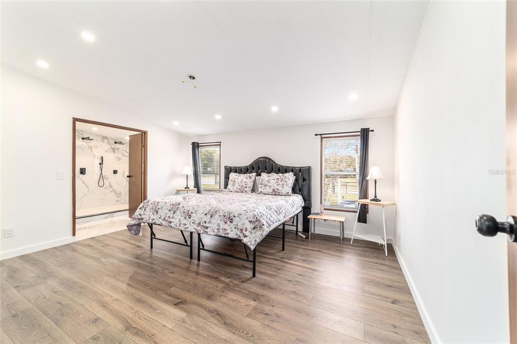 5150 Southeast 117th Avenue Morriston, FL 32668 - Photo 29 of 63 a spacious bedroom with a bed and wooden floor