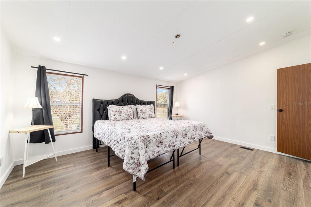 5150 Southeast 117th Avenue Morriston, FL 32668 - Photo 30 of 63 a bedroom with a bed and wooden floor