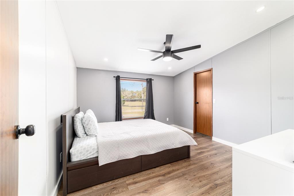 5150 Southeast 117th Avenue Morriston, FL 32668 - Photo 37 of 63 a bedroom with a large bed and a chandelier