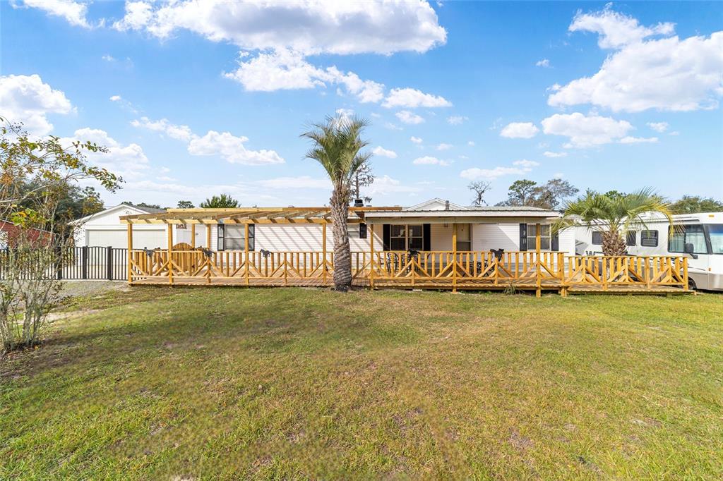 5150 Southeast 117th Avenue Morriston, FL 32668 - Photo 7 of 63 a front view of a house with a garden