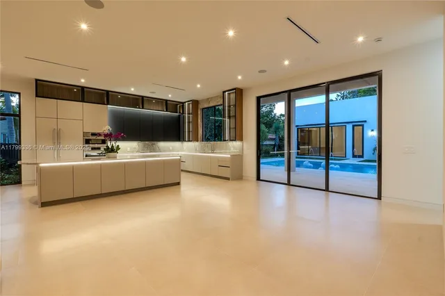 a living room with stainless steel appliances kitchen island furniture and a flat screen tv