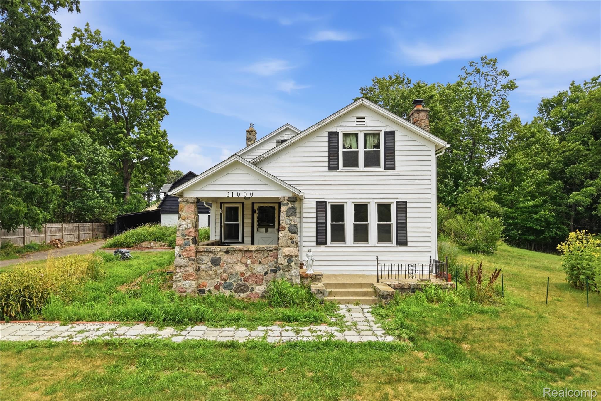 White siding exterior with a stone-accented porch