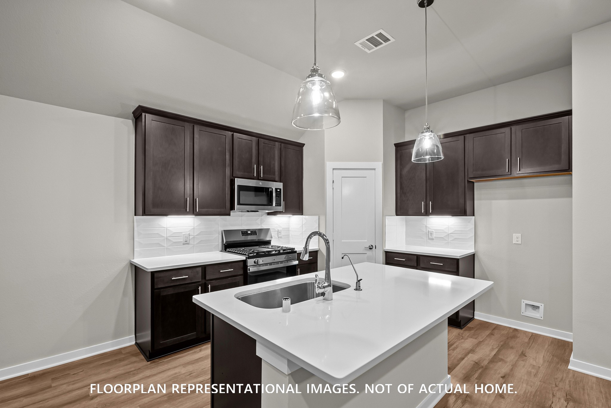 213 Draper Shadows Drive Willis, TX 77378 - Photo 4 of 19 a kitchen with a sink a microwave a refrigerator and cabinets