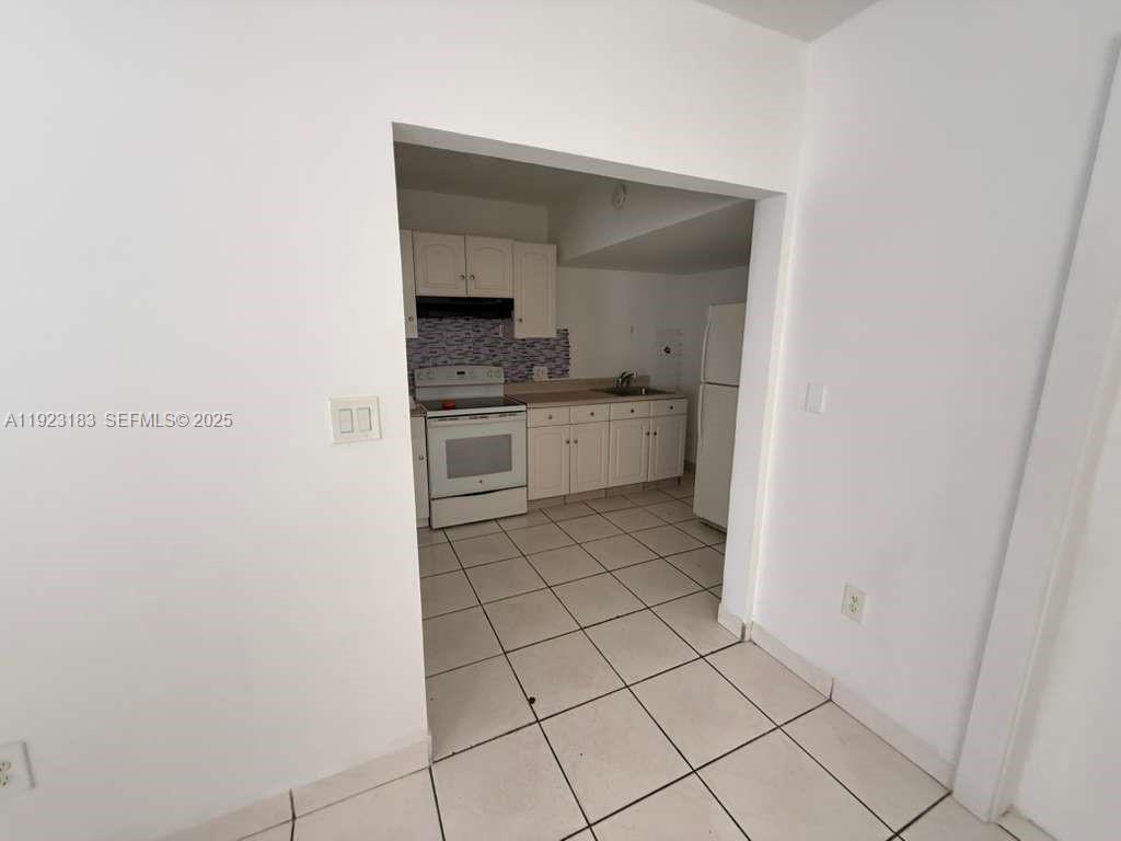 526 Southwest 64th Avenue, Unit 2 Miami, FL 33144 - Photo 7 of 9 a kitchen with white cabinets and appliances