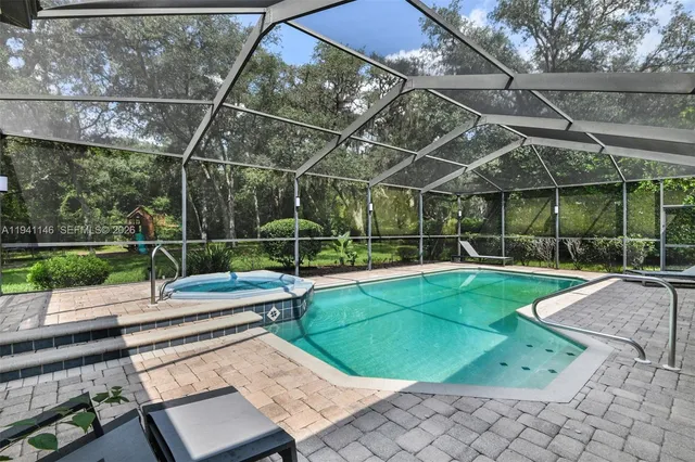 an aerial view of a house with a swimming pool and garden