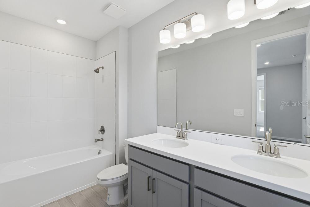 1014 Top Minnow Road St. Cloud, FL 34771 - Photo 21 of 39 a bathroom with a double vanity sink mirror toilet and bathtub