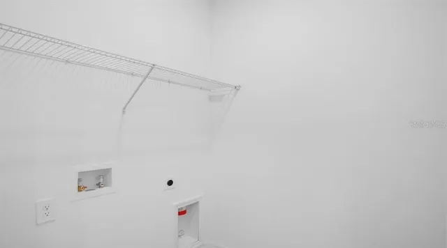 a view of an empty room and kitchen with a sink