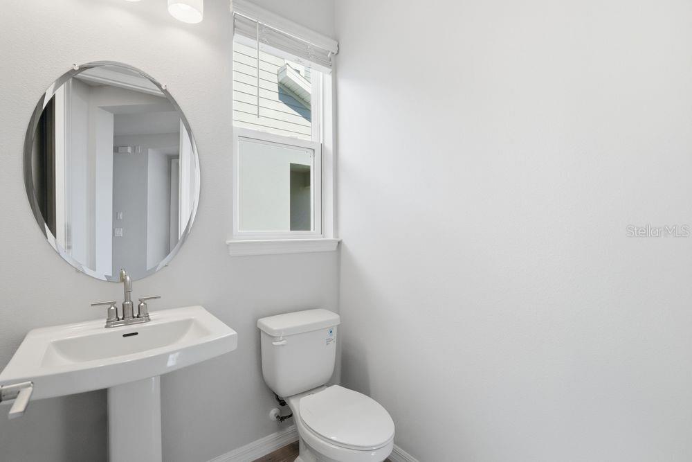 1014 Top Minnow Road St. Cloud, FL 34771 - Photo 24 of 39 a bathroom with a toilet a sink and mirror