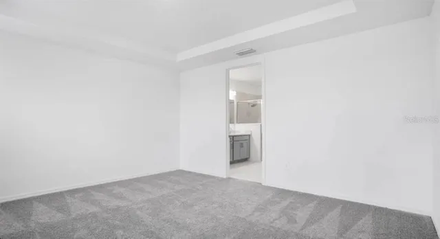 a view of an empty room with wooden floor and windows