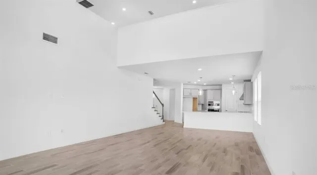 a view of empty room with kitchen and window