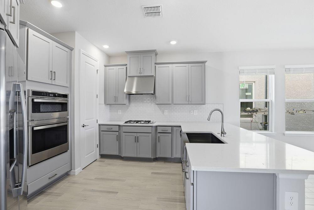 1014 Top Minnow Road St. Cloud, FL 34771 - Photo 4 of 39 a kitchen with stainless steel appliances granite countertop a sink stove and refrigerator