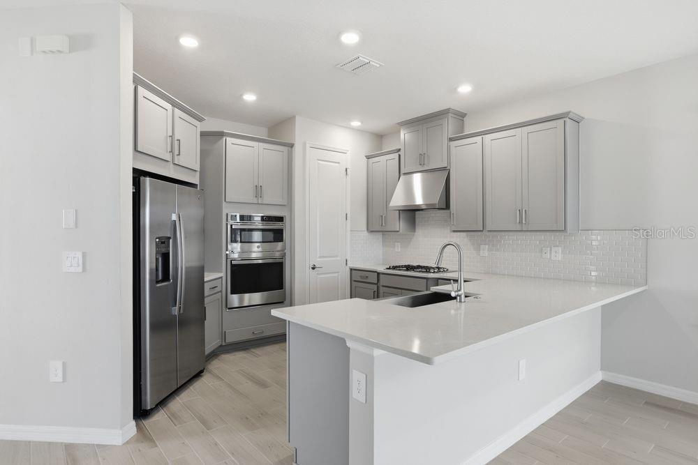 1014 Top Minnow Road St. Cloud, FL 34771 - Photo 5 of 39 a kitchen that has a lot of cabinets and refrigerator