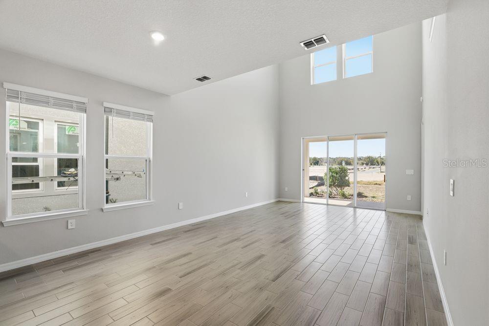 1014 Top Minnow Road St. Cloud, FL 34771 - Photo 7 of 39 wooden floor in an empty room with a window