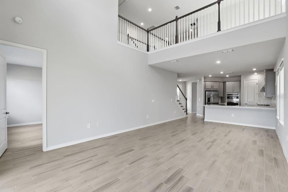 1014 Top Minnow Road St. Cloud, FL 34771 - Photo 8 of 39 a view of a hallway with wooden floor and a kitchen