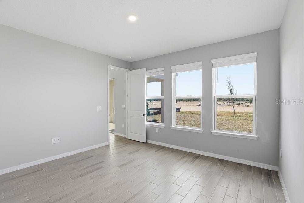 1014 Top Minnow Road St. Cloud, FL 34771 - Photo 9 of 39 an empty room with wooden floor and windows