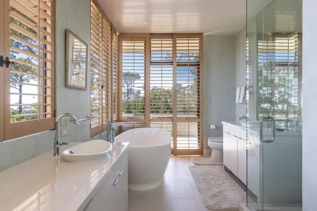a bathroom with a tub sink and mirror