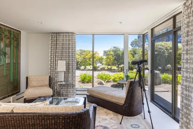 a bedroom with a bed and a large window with the outer view