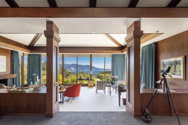 a living room with furniture a fireplace and a floor to ceiling window