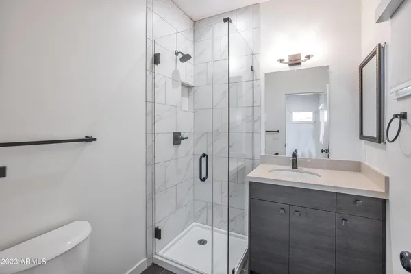 a bathroom with a shower a sink and toilet