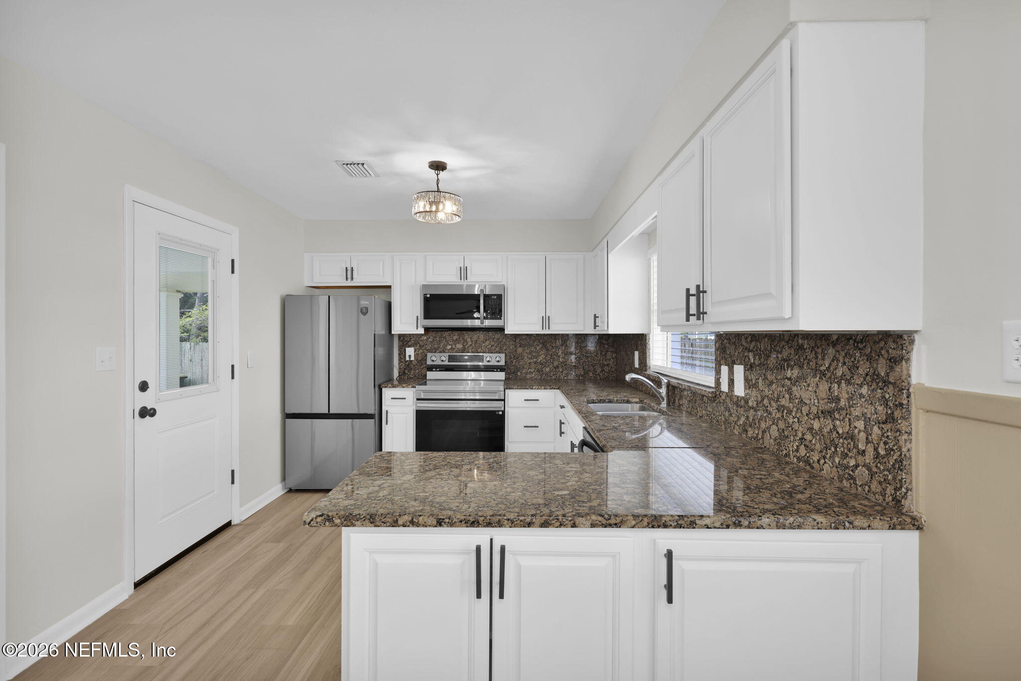8544 Sanchez Road Jacksonville, FL 32217 - Photo 25 of 46 a kitchen with granite countertop a refrigerator a stove a microwave and cabinets