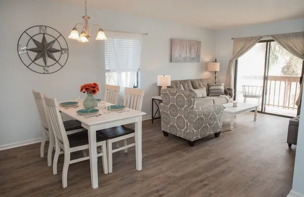 a living room with furniture dining table and a large window