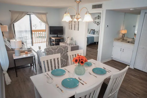 a view of a dining room with furniture a chandelier and wooden floor