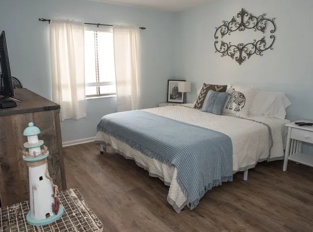 a bedroom with a bed and wooden floor