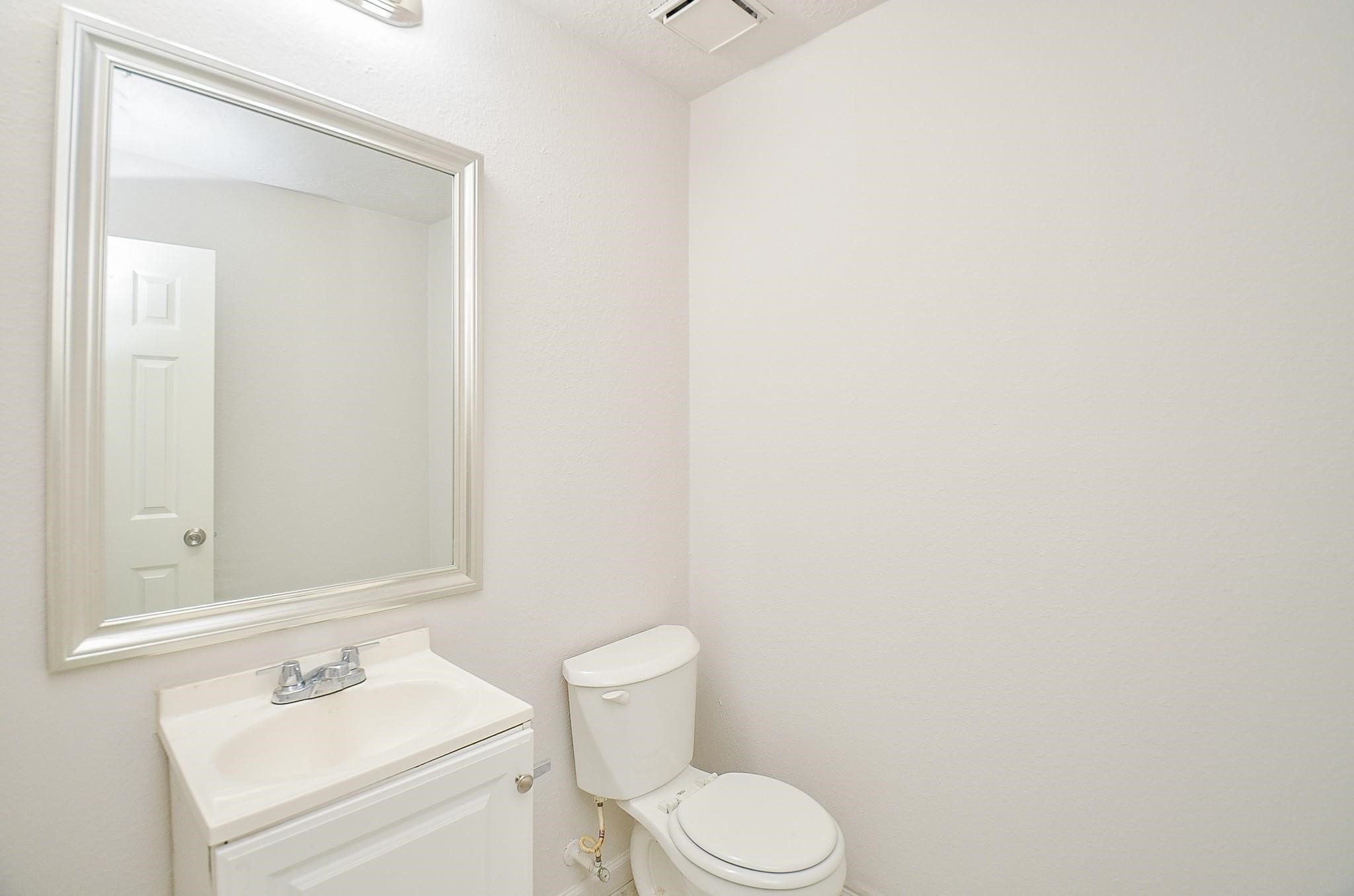 11818 Spring Grove Drive Houston, TX 77099 - Photo 12 of 18 a white toilet sitting next to a bathroom sink