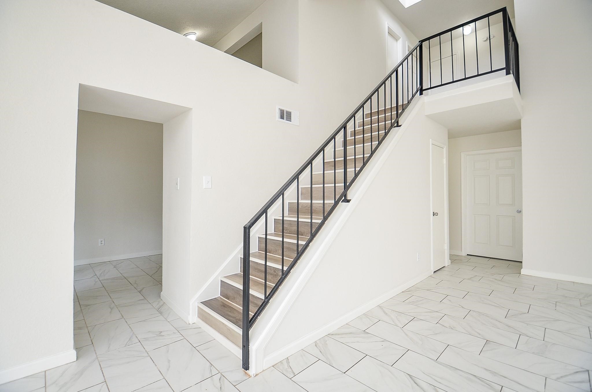 11818 Spring Grove Drive Houston, TX 77099 - Photo 6 of 18 a view of staircase with white walls and railing