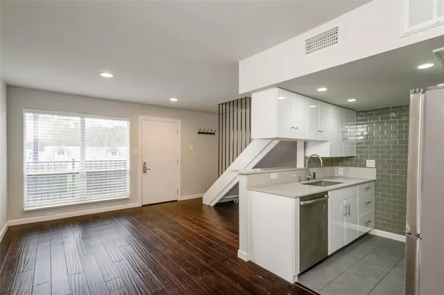a kitchen with a sink and wooden floor