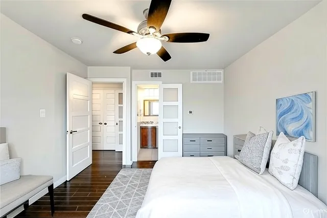 a spacious bedroom with a large bed and ceiling fan