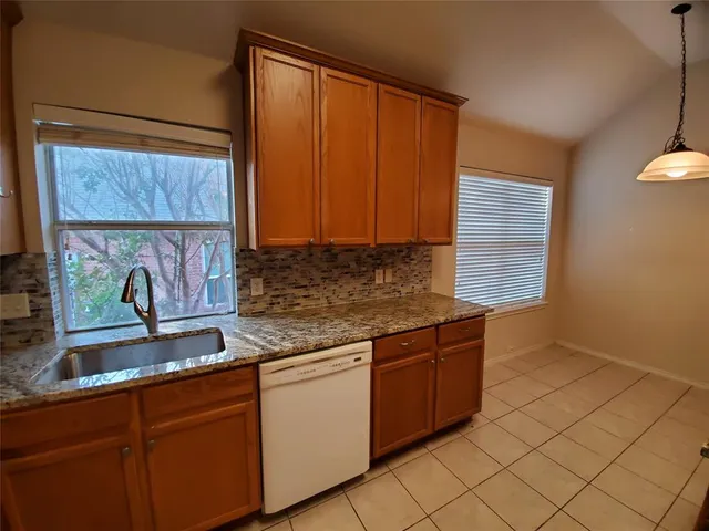 a kitchen with stainless steel appliances granite countertop a sink and a white cabinets