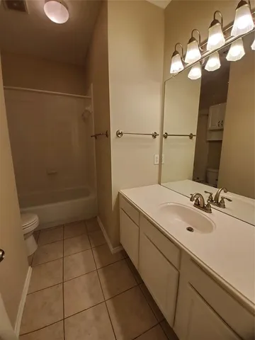 a bathroom with a granite countertop sink a toilet and mirror