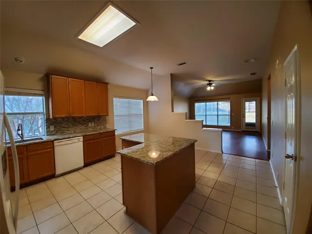 a kitchen with granite countertop a sink and a stove top oven
