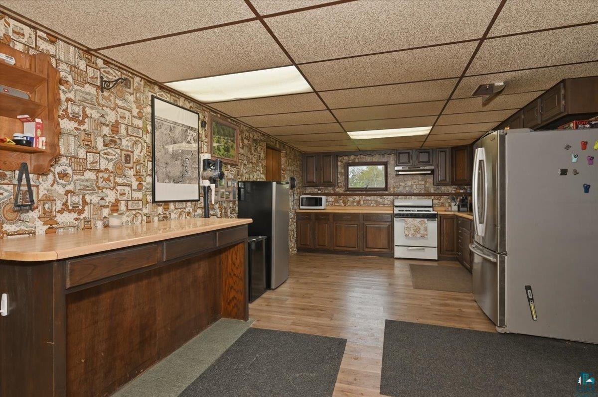 5190 County Road M Gordon, WI 54838 - Photo 8 of 31 Kitchen area featuring wood-finish flooring, dark wood cabinetry, and laminate countertops