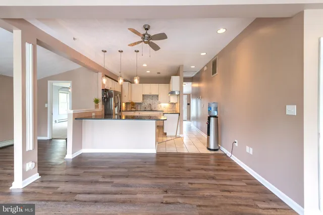 a view of kitchen with kitchen island refrigerator stove and wooden floor