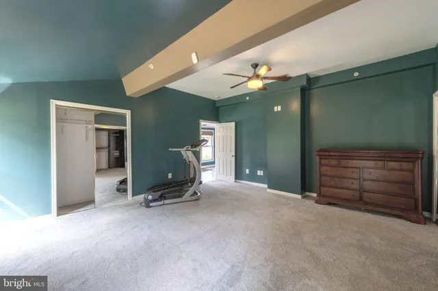 a view of a room with furniture and a ceiling fan