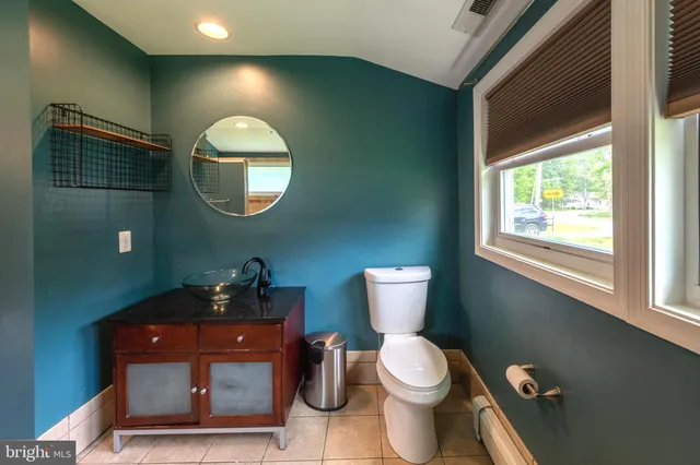 a bathroom with a toilet sink and mirror