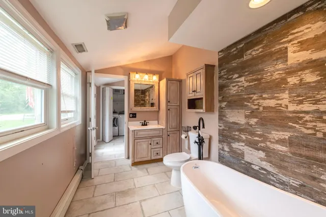 a large bathroom with a tub a sink a mirror and a shower