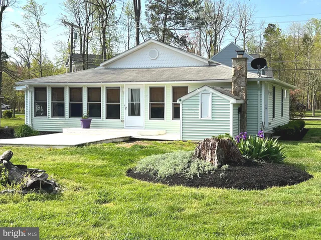 a front view of a house with a yard and potted plants