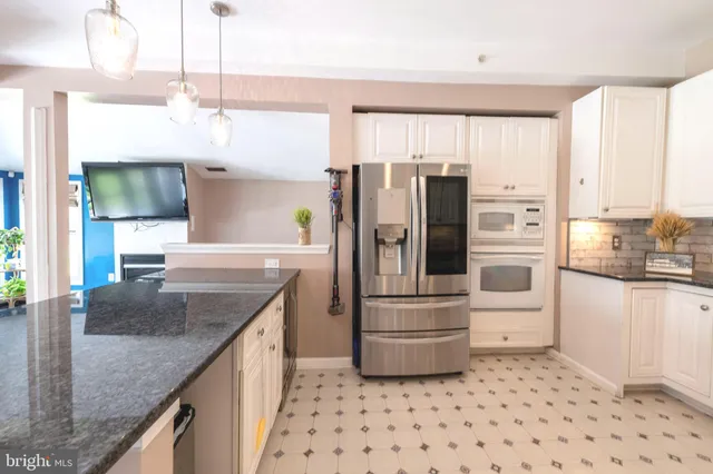 a kitchen with granite countertop a refrigerator and a sink