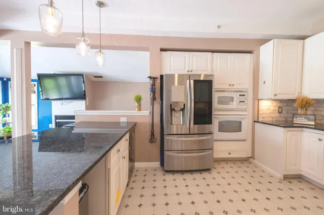 a kitchen with granite countertop a refrigerator and a sink