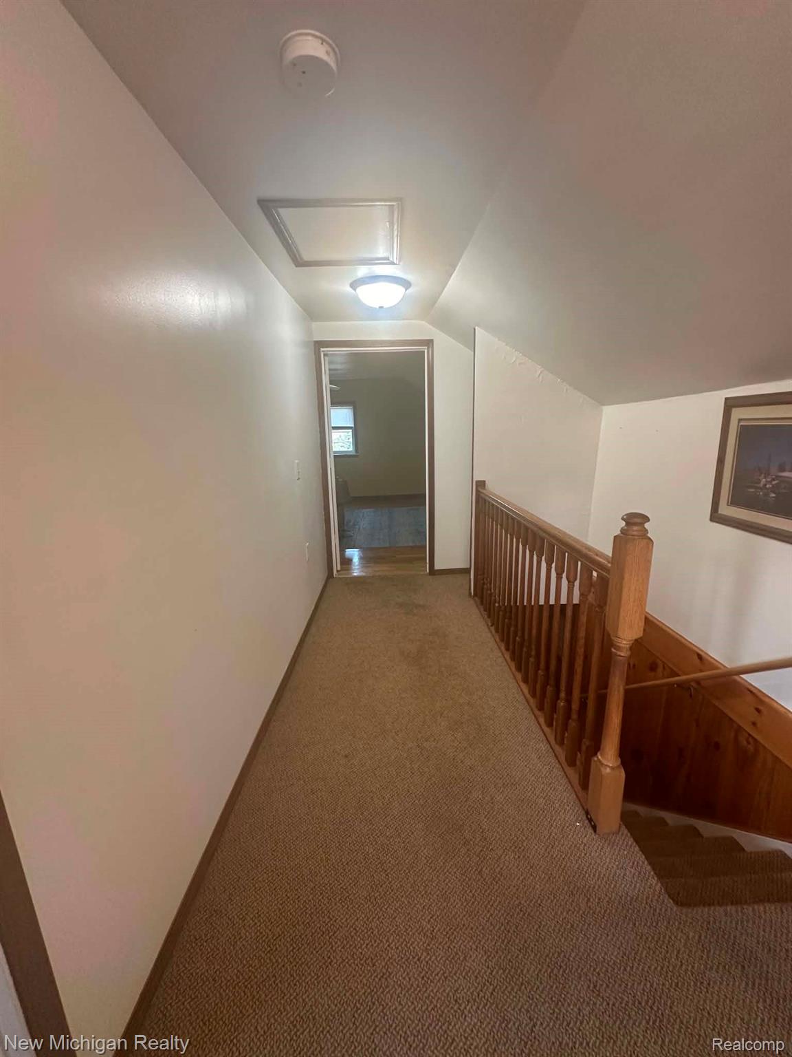 7415 Farrand Road Clio, MI 48420 - Photo 24 of 31 Carpeted hallway with wood-finish railing and sloped ceilings