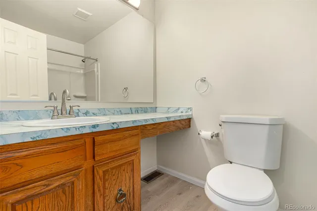 a bathroom with a granite countertop toilet sink and mirror