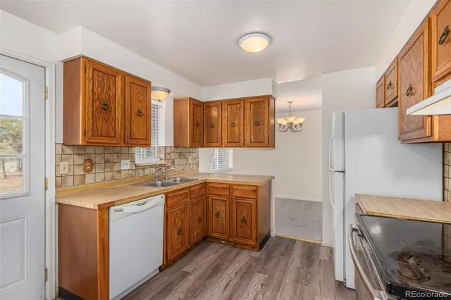 a kitchen with stainless steel appliances a sink cabinets and wooden floor