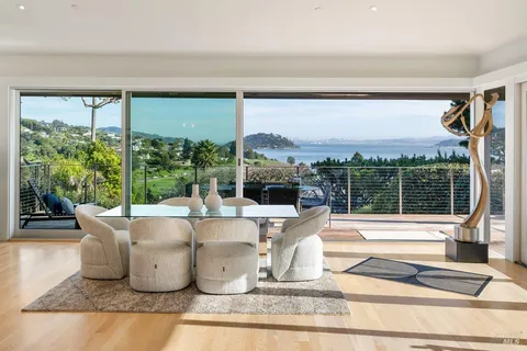 a dining room with couches a coffee table and a flat screen tv