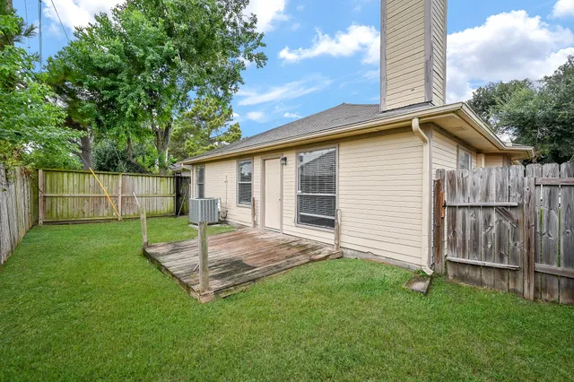 a view of a backyard with table and chairs and wooden fence
