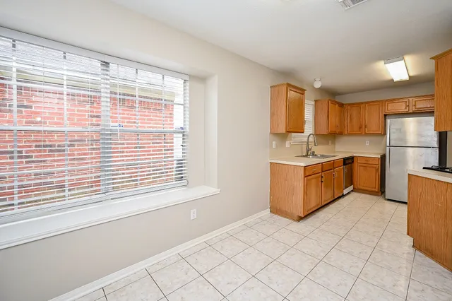 a kitchen with stainless steel appliances granite countertop a stove a sink and a refrigerator