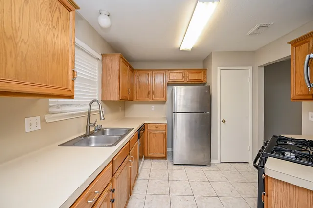 a kitchen with a sink a refrigerator and a stove top oven